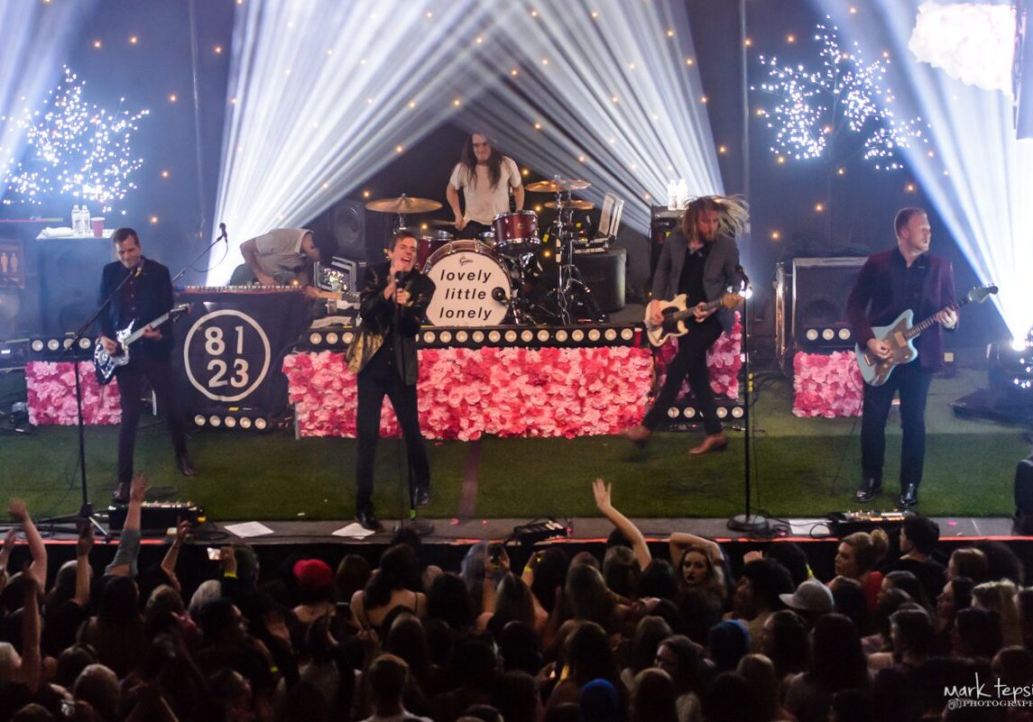 Band performing on stage with colorful lights.