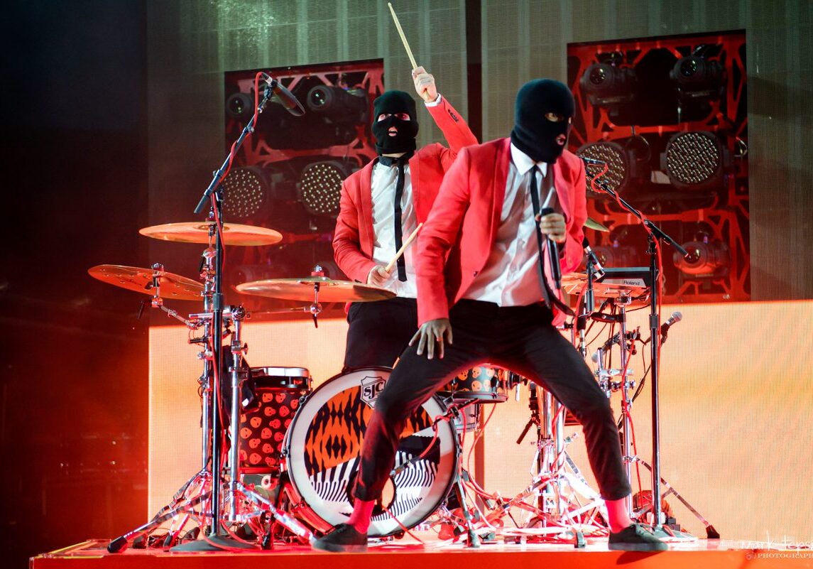 Musicians in red suits performing on stage.