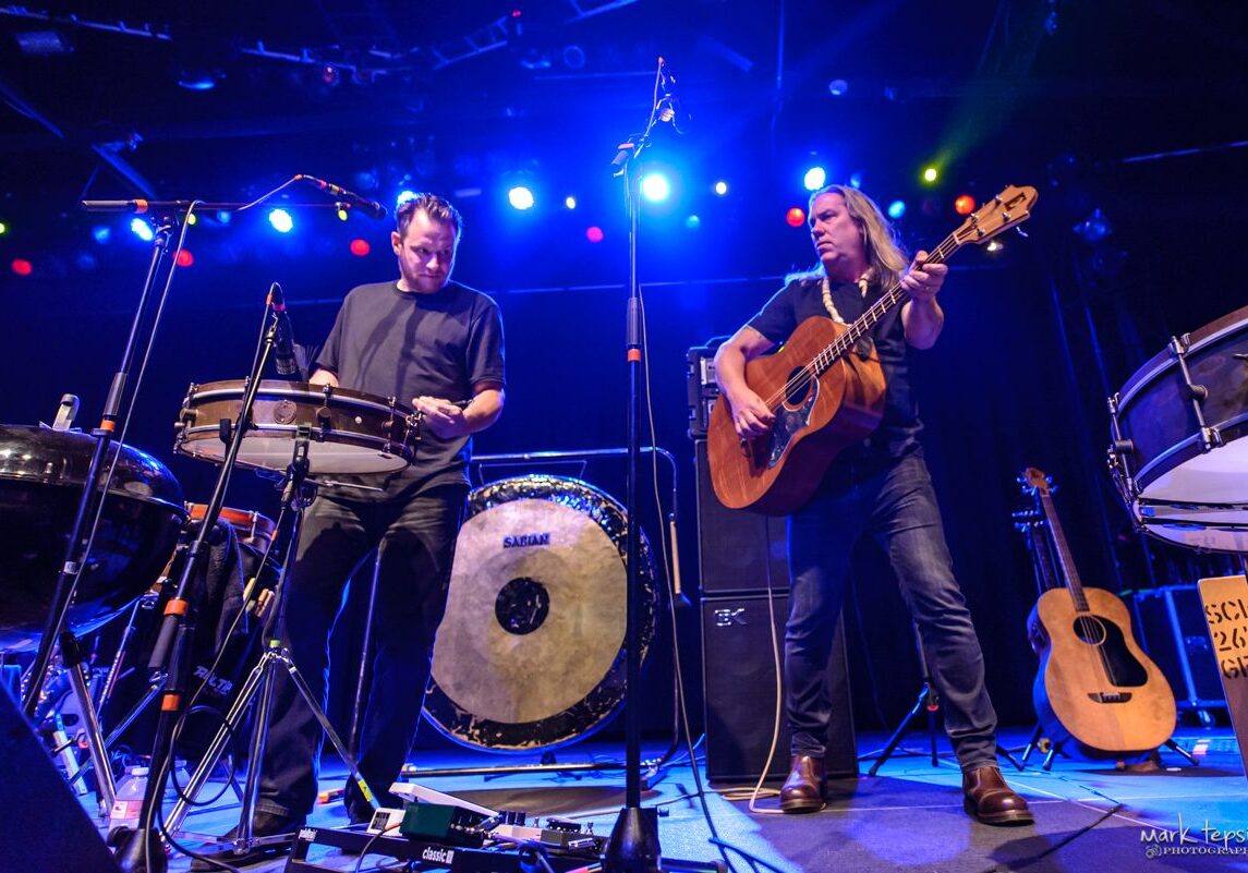 Musicians performing on stage with instruments.