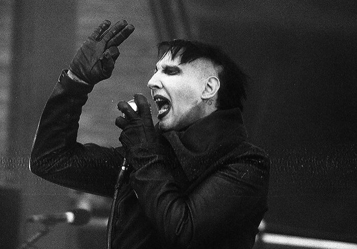 Singer performing energetically on stage.