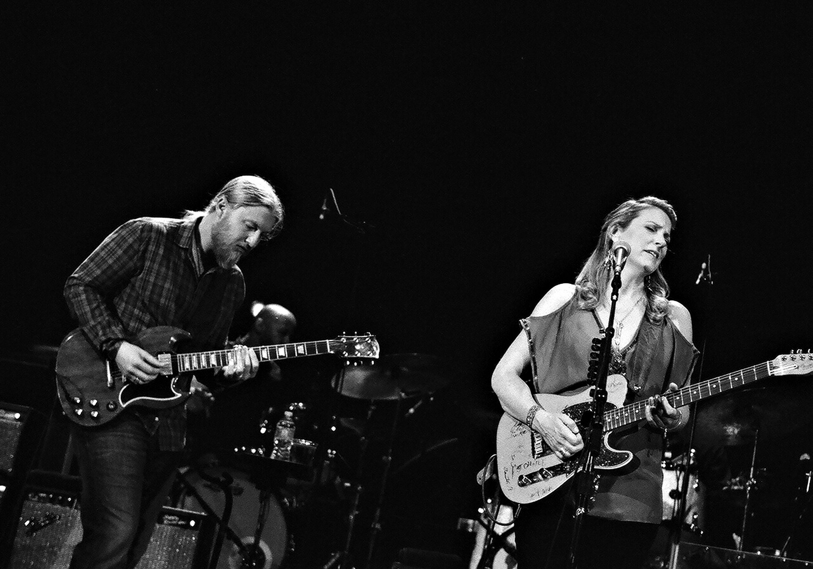 Musicians performing on stage with guitars.