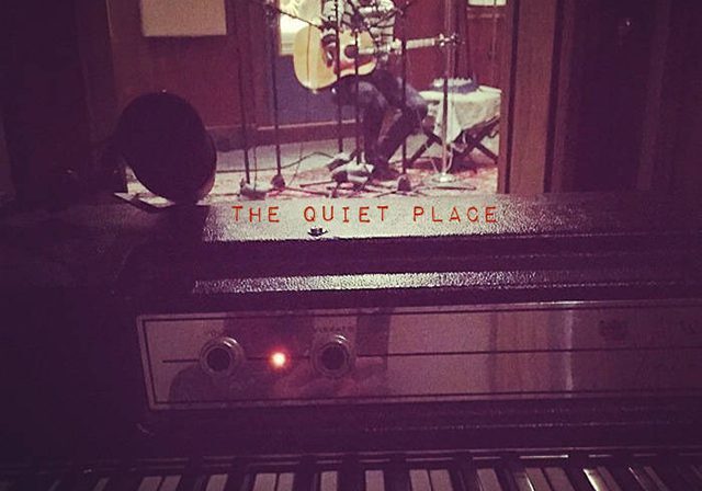 Recording studio with musician playing guitar.