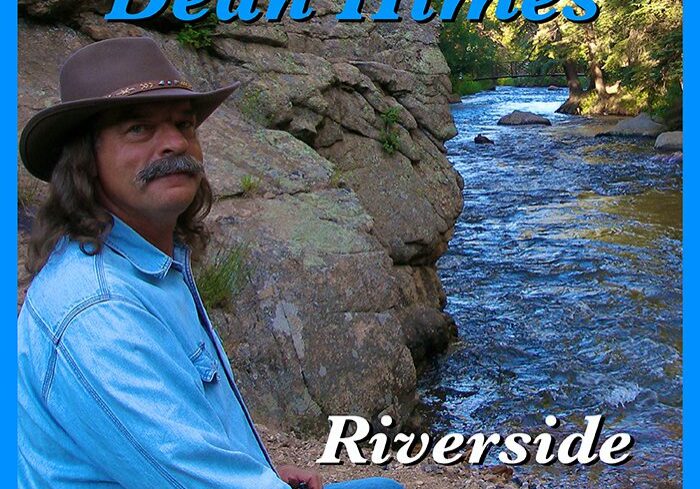 Man sitting by a scenic riverside.