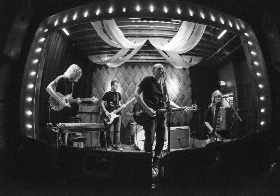 Band performing on stage in black and white.