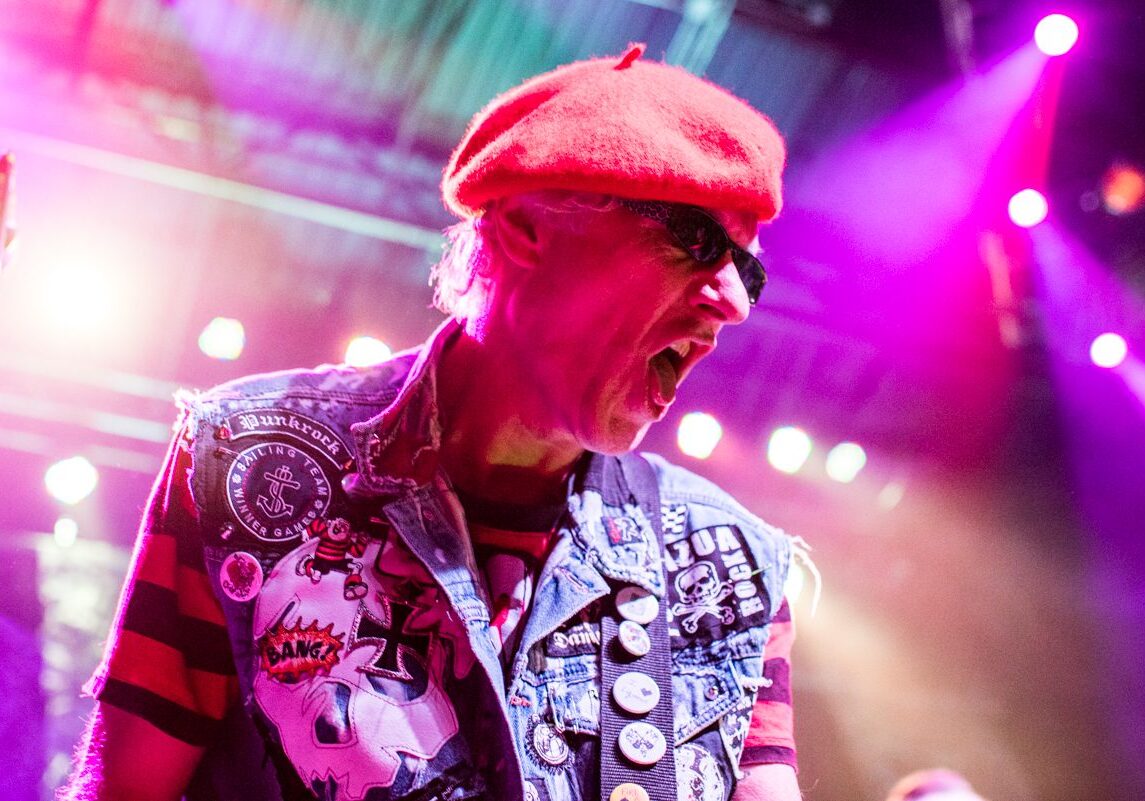 Musician performing energetically on stage.