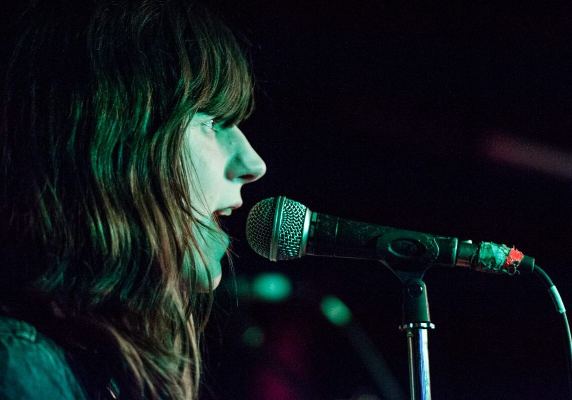 Singer performing on stage with microphone.