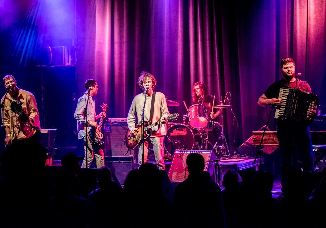 Band performing on stage with instruments.