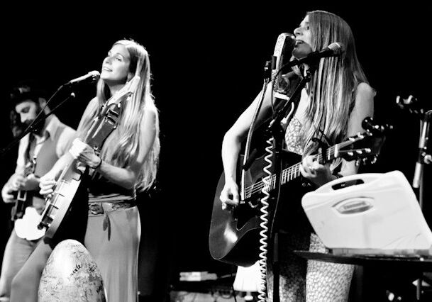 Musicians performing on stage with guitars.