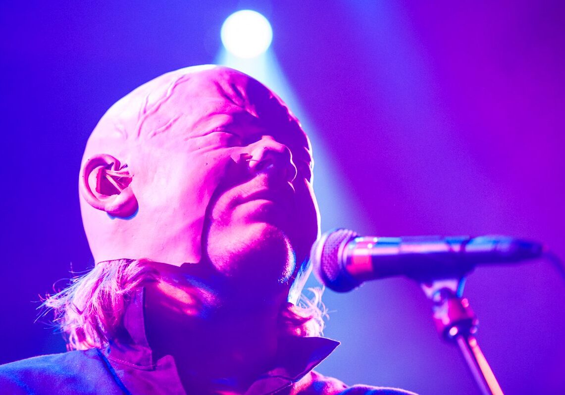 Singer performing under purple stage lights.