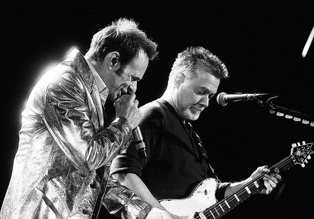 Two musicians performing on stage, black-and-white.