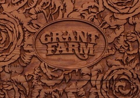 Wooden carving with "Grant Farm" and floral design.