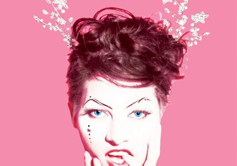 Woman with artistic makeup on pink background.