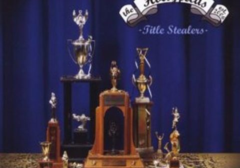 Trophies displayed on a table, blue backdrop.
