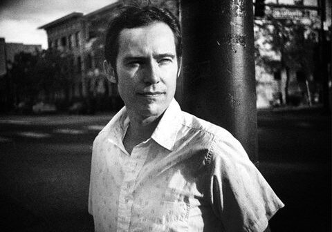 Man standing outdoors, black and white photo.