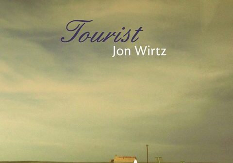 Desert road with distant house, "Tourist" text.