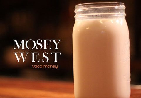 Mason jar of milk on wooden table.