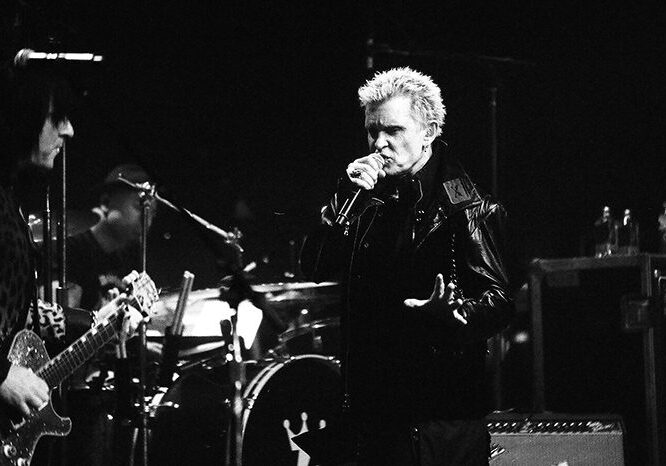 Musician performing on stage with a band.