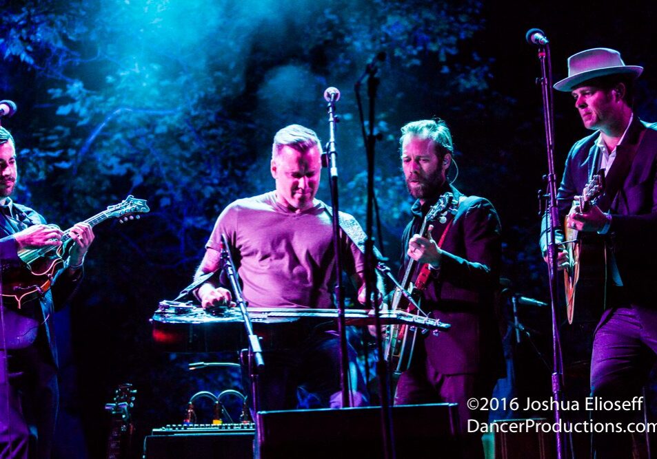 Band performing on stage with blue lighting.