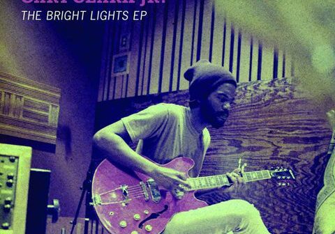 Musician playing guitar in recording studio.