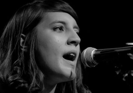 Singer performing on stage with microphone.