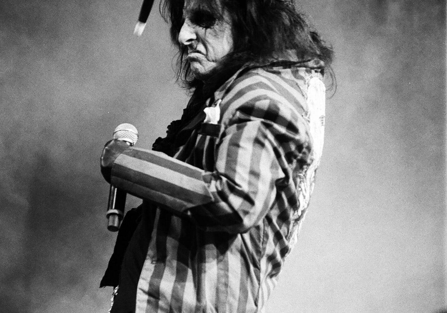 Rock musician performing on stage with microphone.