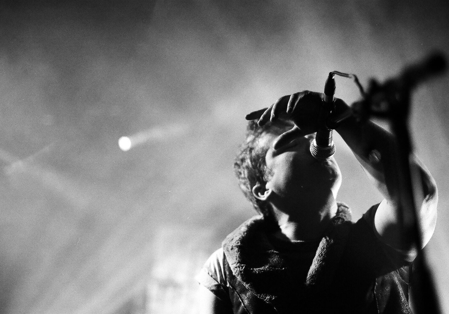 Singer performing passionately on stage, black and white.