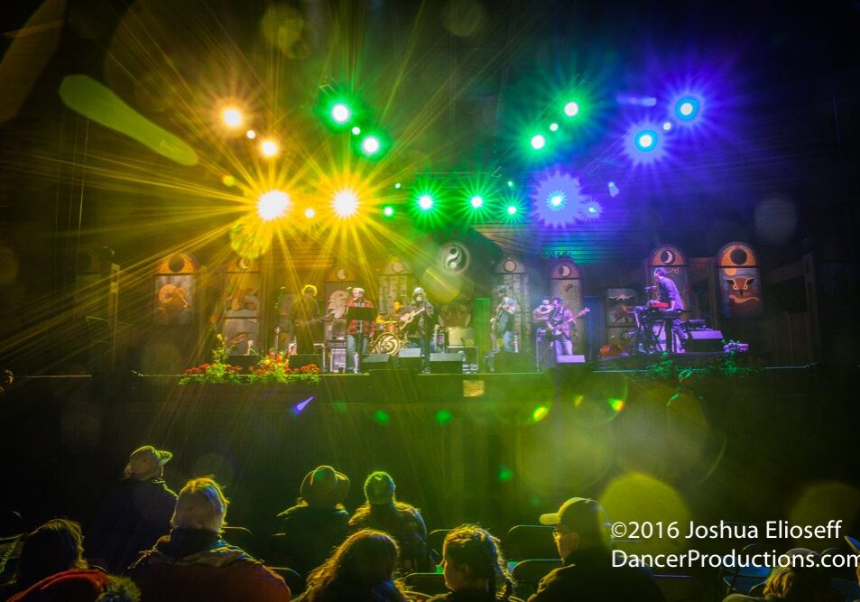 Concert stage with colorful lights and audience.