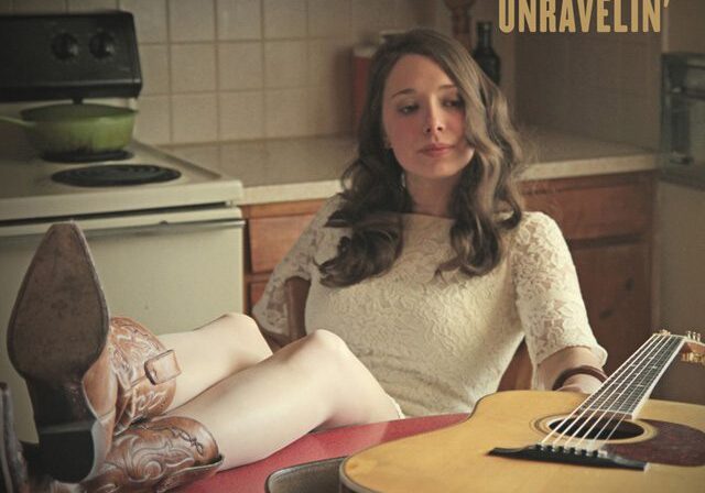 Woman relaxing with guitar in kitchen.