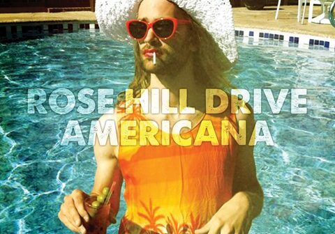 Person in pool with drink and sunglasses.