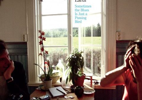 Two people sitting in sunlit room.