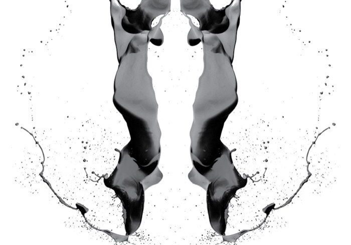 Black inkblot on white background, symmetrical design.