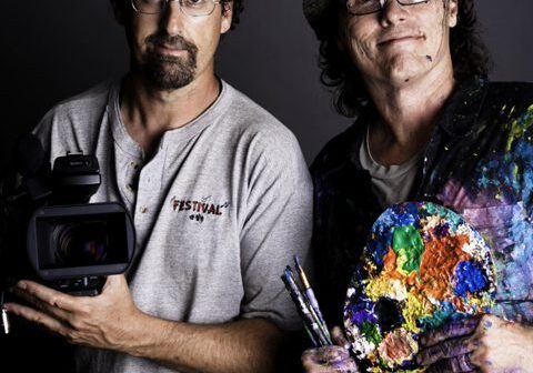 Two artists with camera and paint palette.