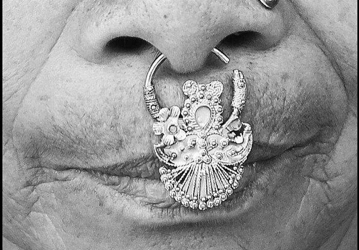 Nose adorned with intricate silver nose ring.