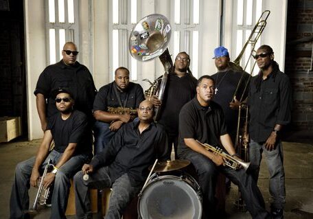 Band members posing with musical instruments.