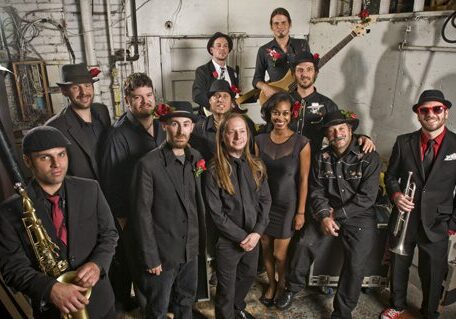 Band posing together in industrial setting.