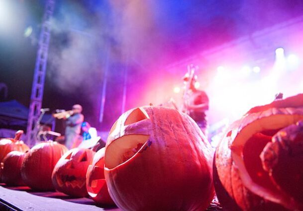 Carved pumpkins at a colorful music event.