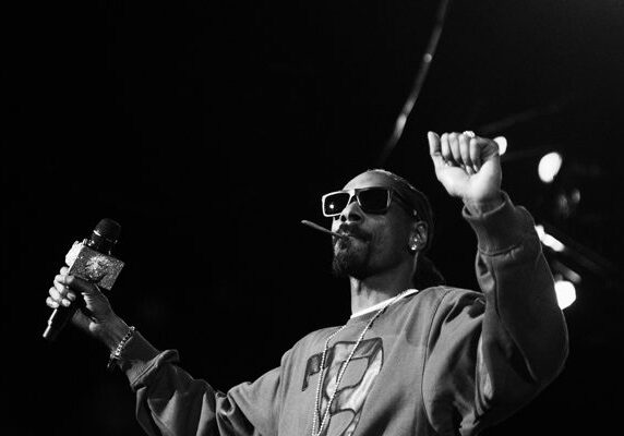 Rapper performing on stage with sunglasses.