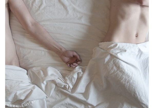 Two people lying on a bed.