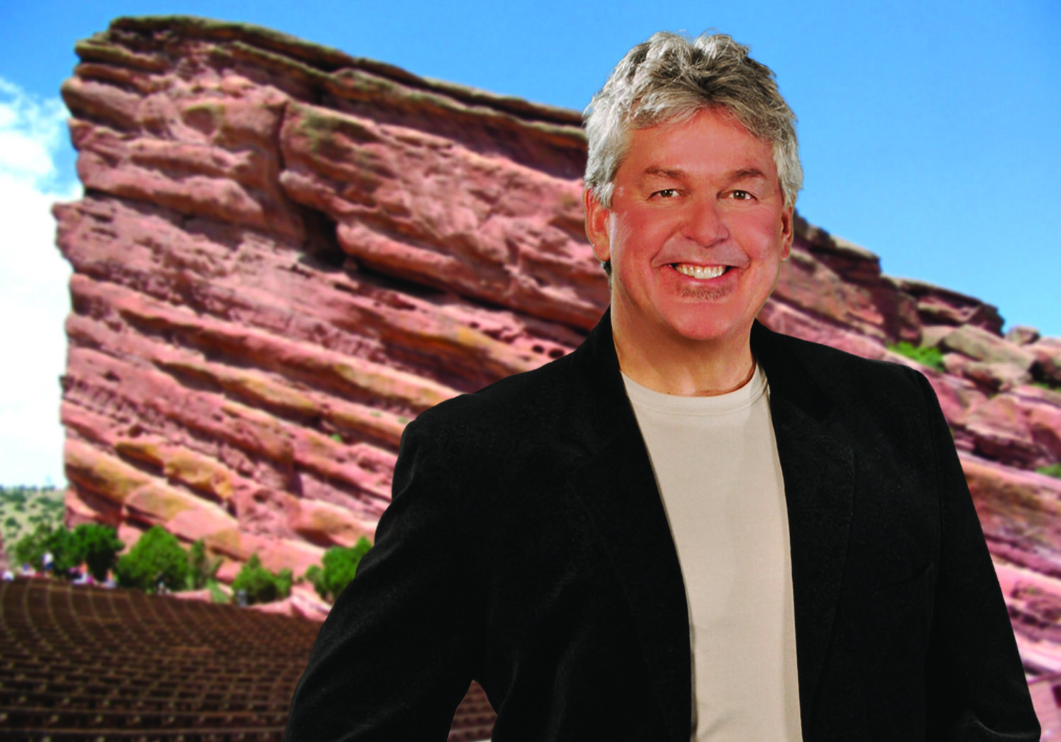 Man smiling in front of red rock formation.