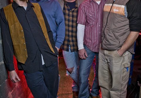 Five men posing in casual attire.