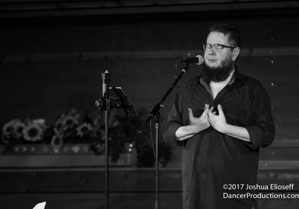 Man singing passionately into a microphone.