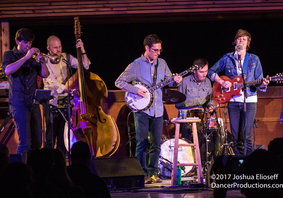 Band performing with various musical instruments.