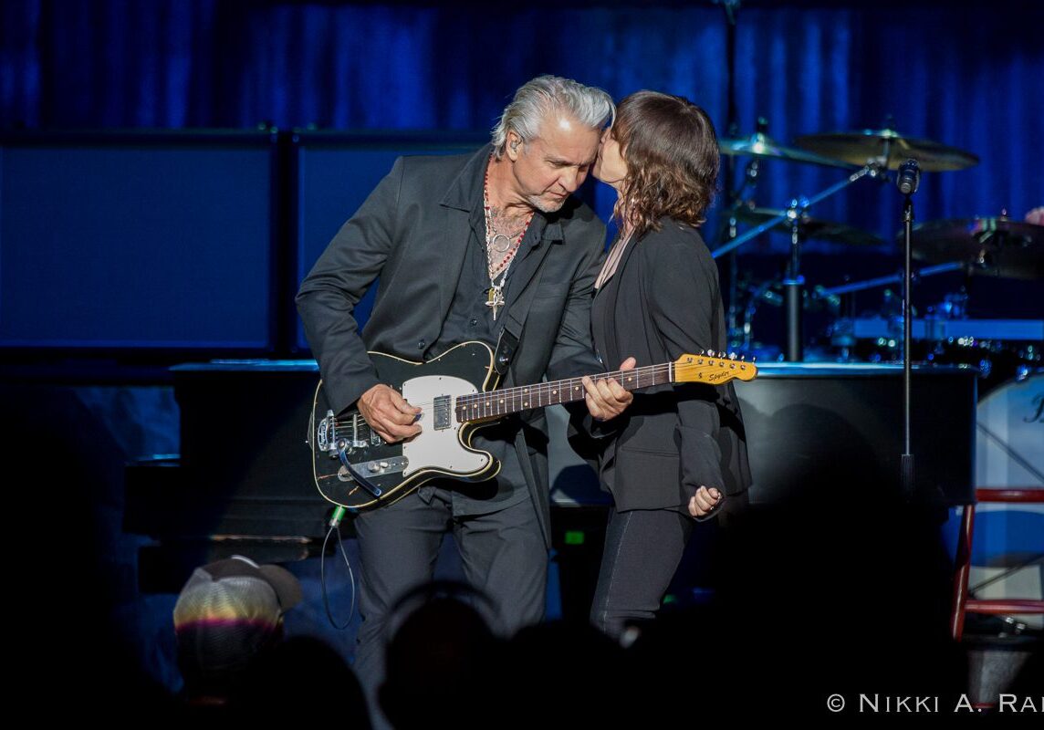 Musicians performing passionately on stage together.