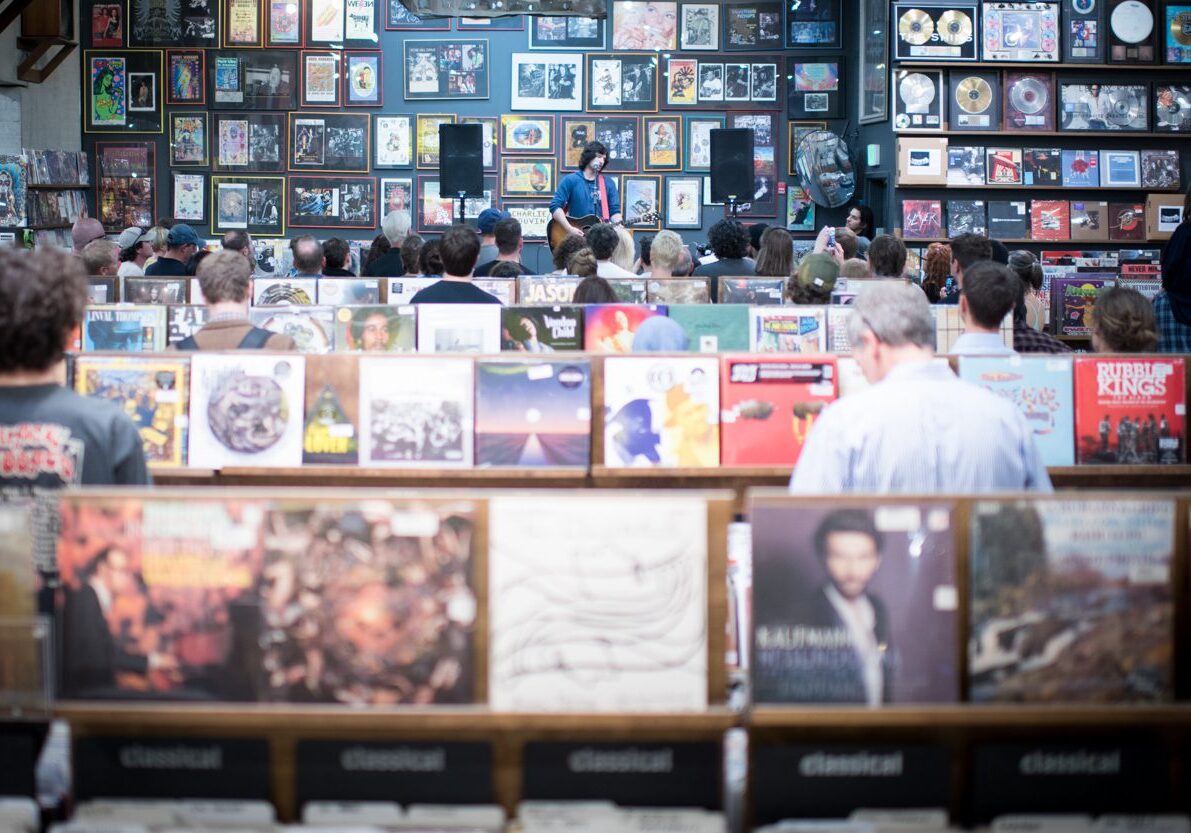 Record store event with audience and albums.