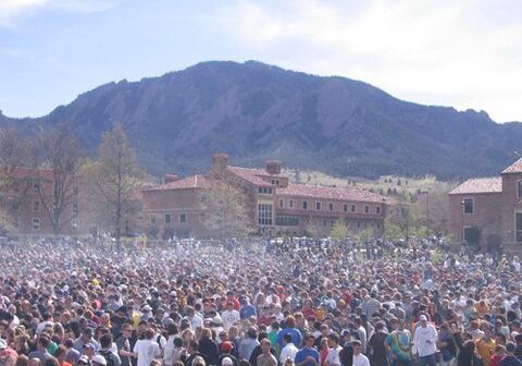 Large crowd gathered outdoors near mountains.
