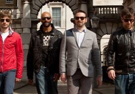 Four men walking in urban setting.