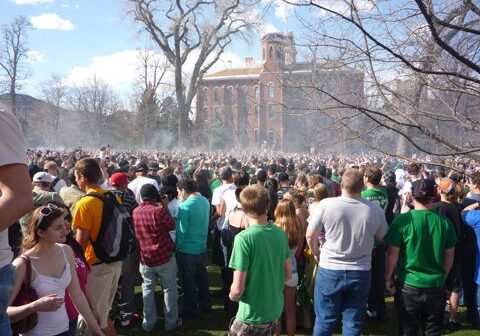 Crowd gathering outdoors near historic brick building.