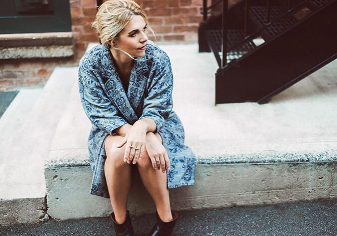 Woman sitting on concrete steps, looking away.