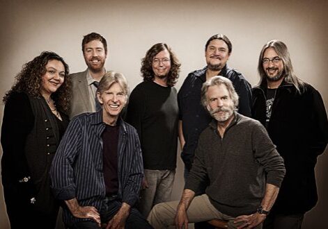 Group of seven people smiling together.