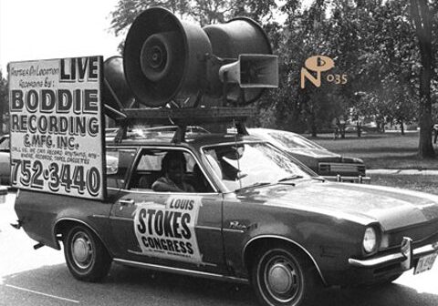 Car with loudspeakers and political campaign signs.